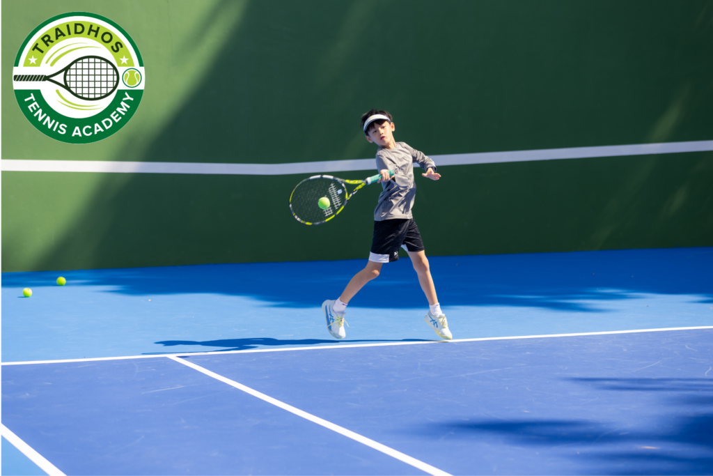 A student playing tennis on an outdoor court at Prem International School
